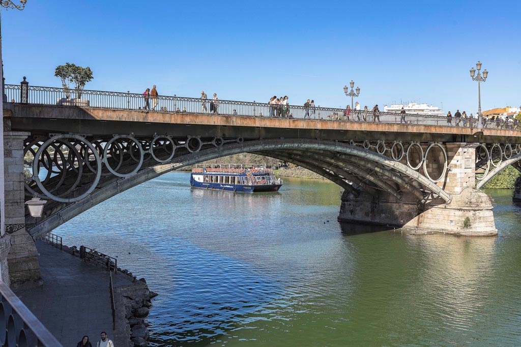 foto del puente de triana con barco pasando