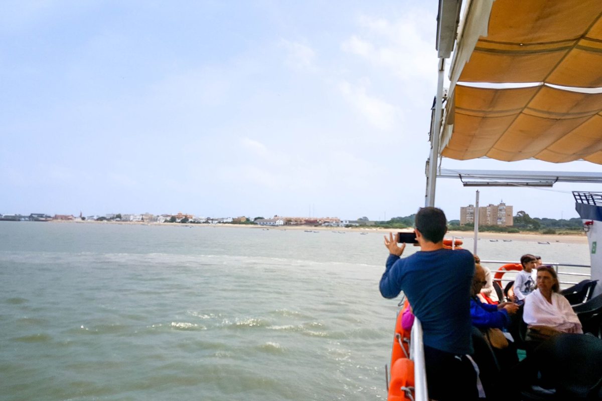 Hombre admira el paisaje de Sanlúcar de Barrameda desde la cubierta superior del barco